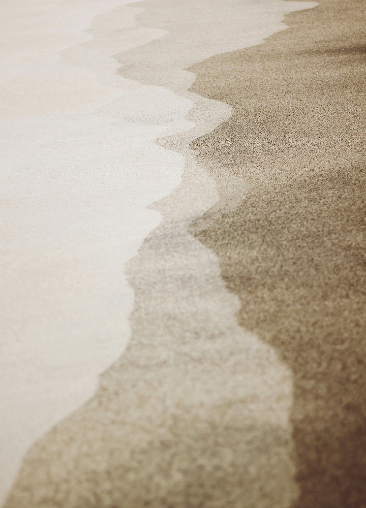 abstract view of a shoreline where light beige sand meets darker wet sand, forming a wavy line along the diagonal from left to right, with subtle texture and gradient.