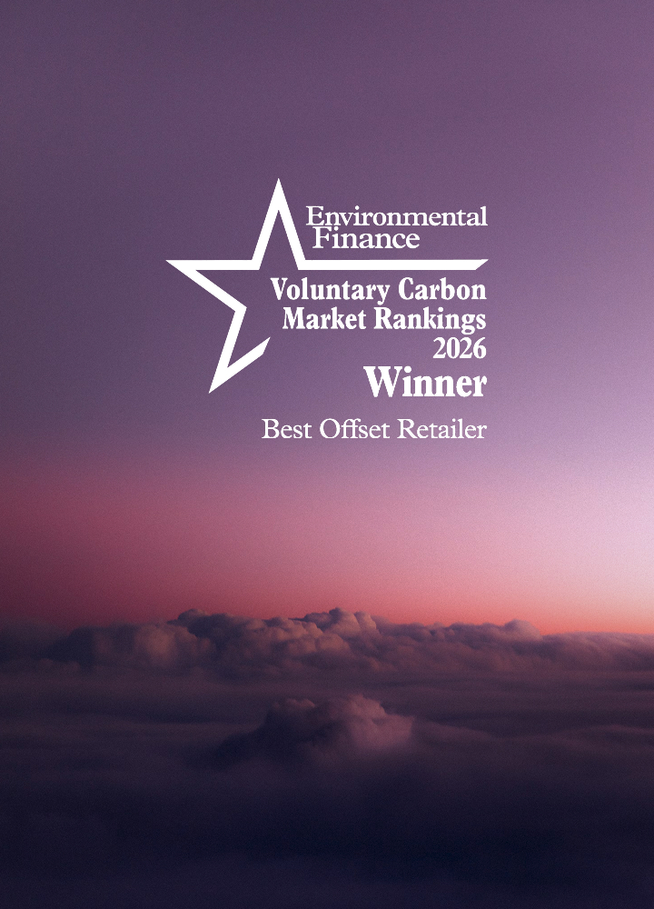 Award insignia with a white star graphic and stacked text reading Environmental Finance, Voluntary Carbon Market Rankings 2026, Winner, Best Offset Retailer, set against a purple-pink sky and clouds.