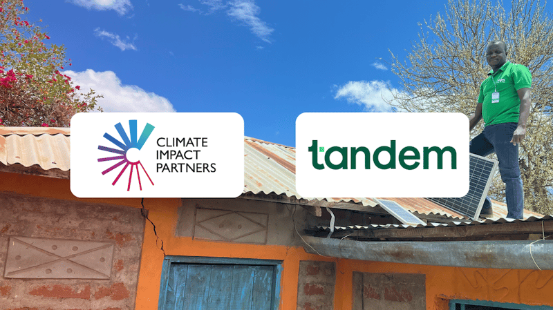 Two logos displayed on a roof: Climate Impact Partners on the left and tandem on the right, with a man in a green shirt standing on solar panels above a colorful building.