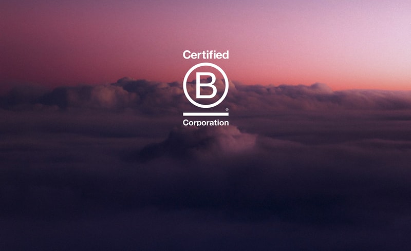 A purple-pink cloudy sky as seen from above, with a centered white logo reading Certified B Corporation over horizontal lines.