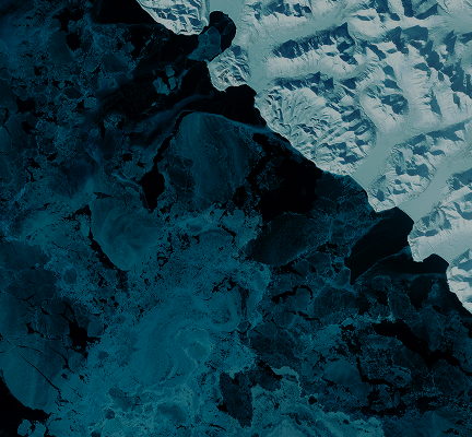 Aerial view of icy, rugged terrain with pale snow on upper right and dark, jagged rock and ice formations spreading across the lower left.