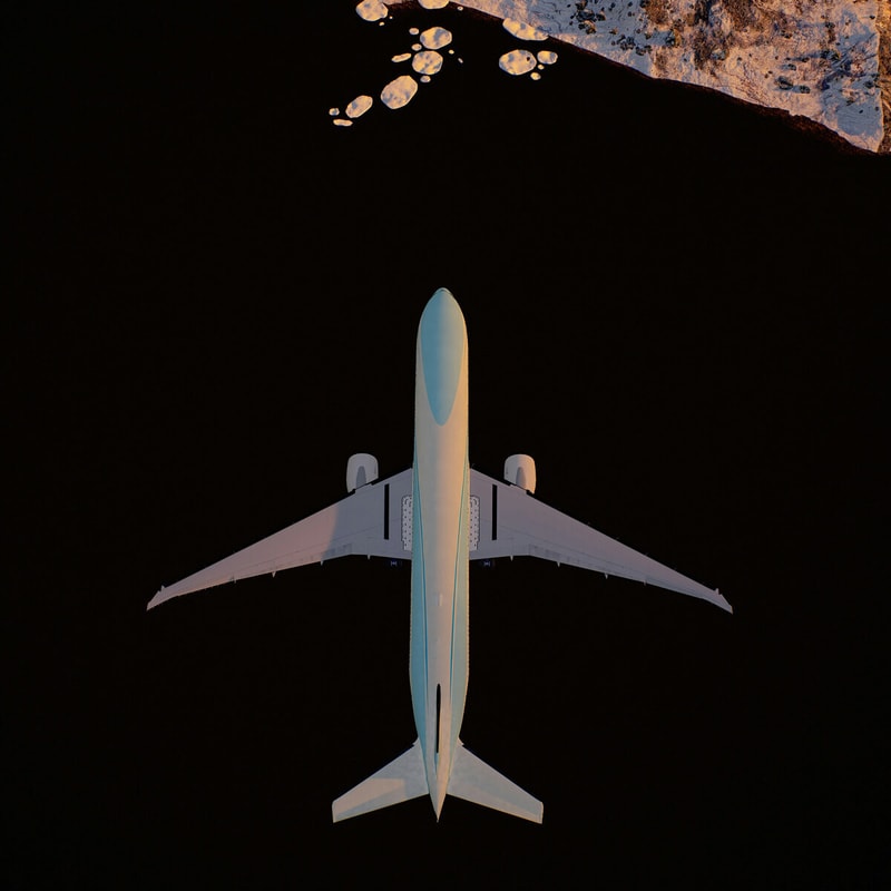 top-down view of a large commercial airplane flying over dark space with a rocky, sunlit coastline visible at the top edge